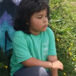 Adrián sentado en la montaña mirando hacia la ciudad